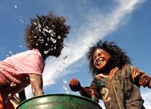 Children washing their faces and playing under the blue sky