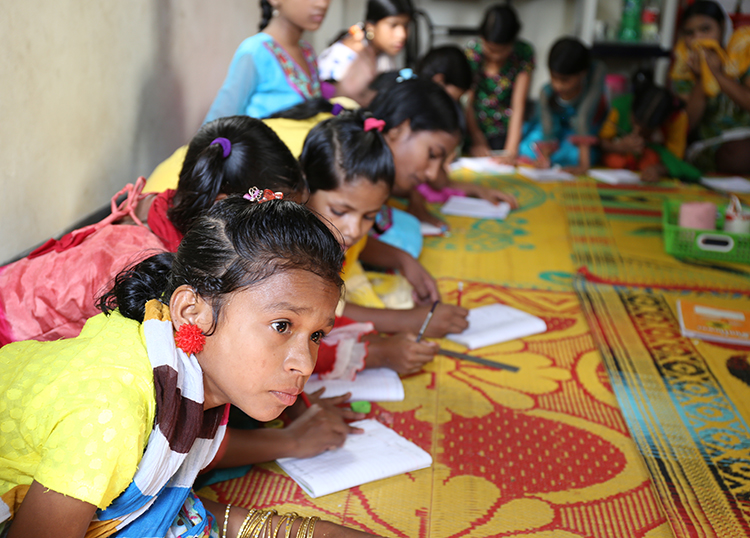 Girls learning reading and writing skills at our support center