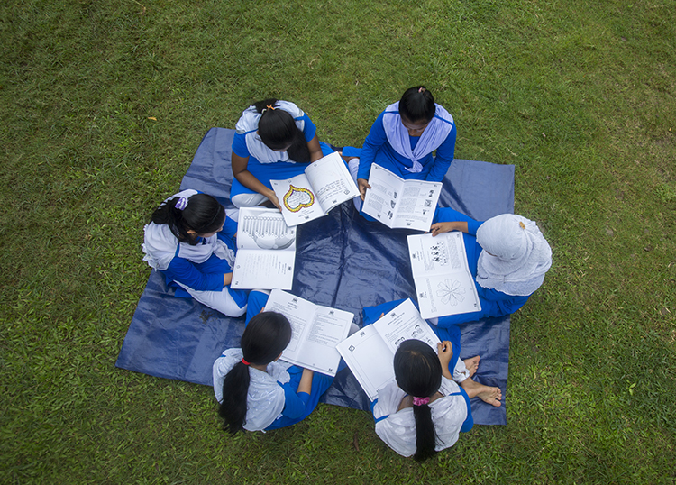 Helping each other with classmates. Female students reviewing classwork with their friends.